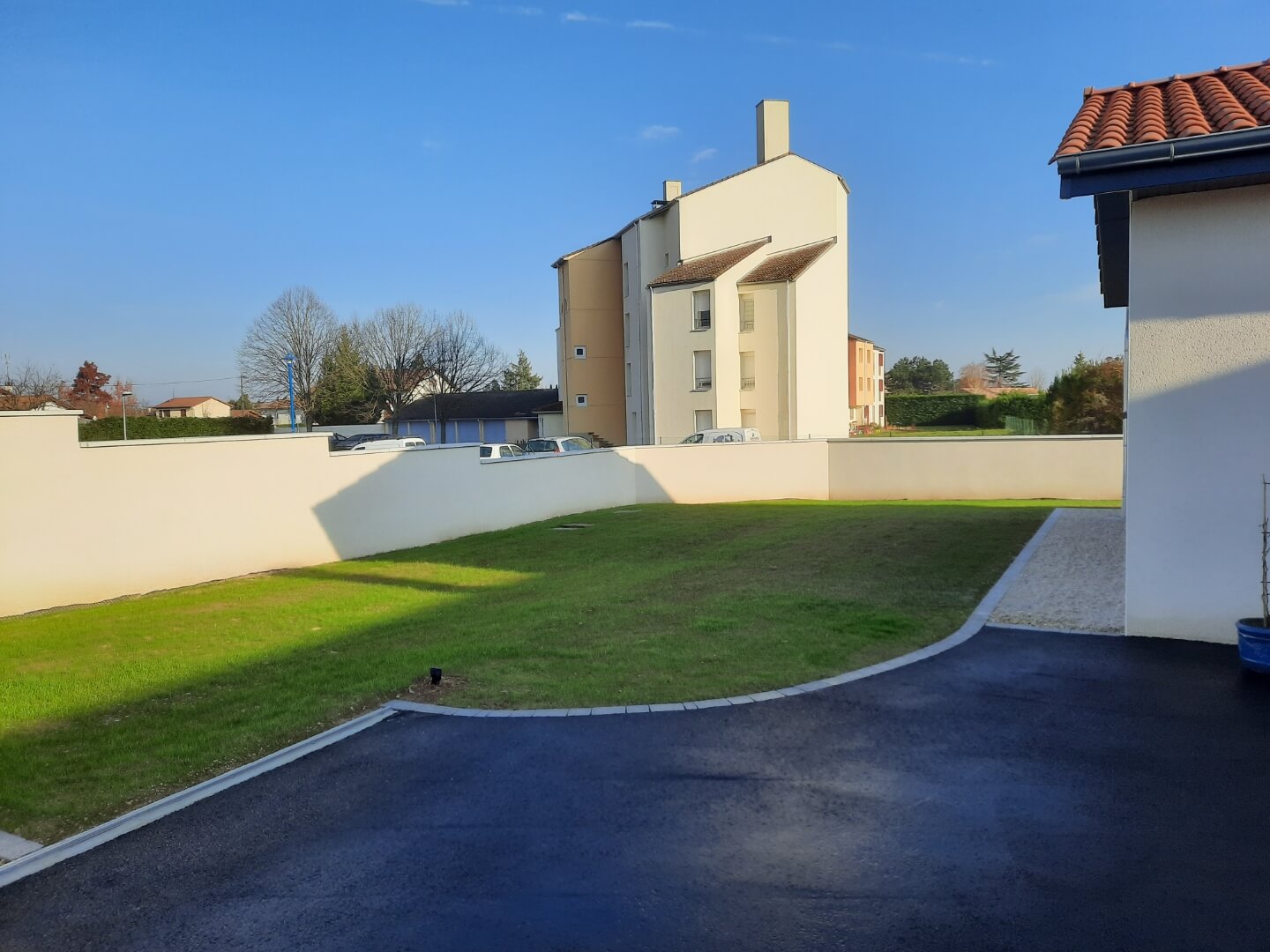 Réalisation complète d‘une cour avec enrobé à motifs, plantations et cheminement.